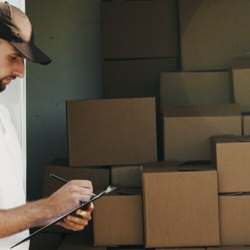 Hub logistique automatisé avec opérateurs utilisant des scanners codes-barres et des robots de manutention