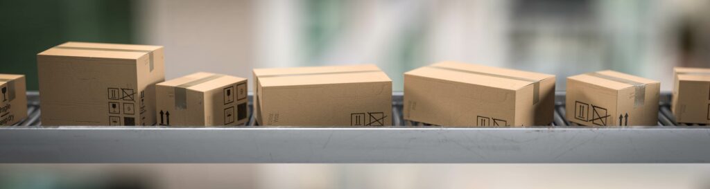 Cartons e-commerce sur un convoyeur dans un entrepôt logistique